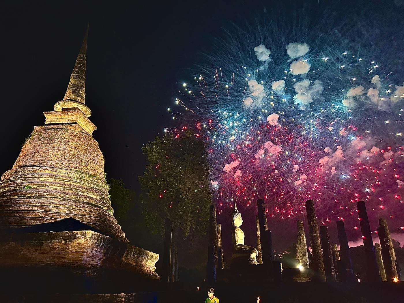 Fireworks light up the ancient stupas and Buddha statues in Sukhothai Ancient City